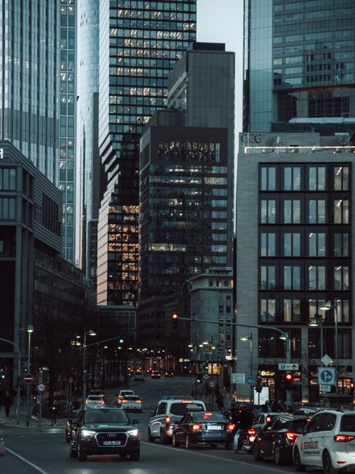 Free Evening traffic in a modern city with towering skyscrapers and bustling city life. Stock Photo