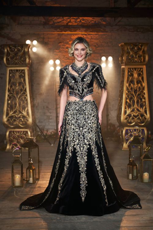 Free Stunning portrait of a woman in a decorative black gown with intricate gold patterns. Stock Photo