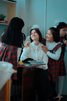 Teacher enjoying a happy moment with smiling schoolgirls in the classroom.