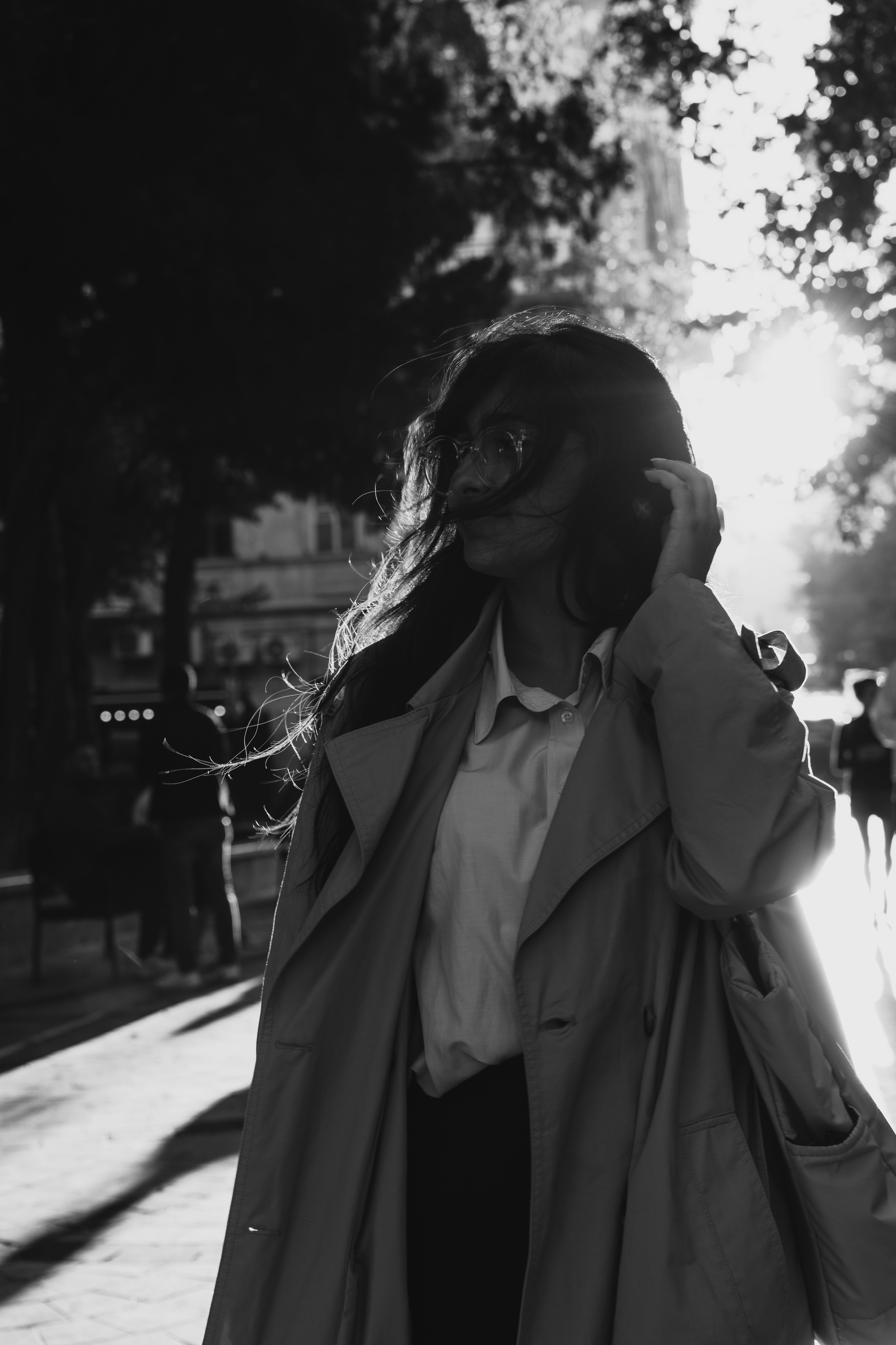 A woman in a trench coat walking down the street · Free Stock Photo