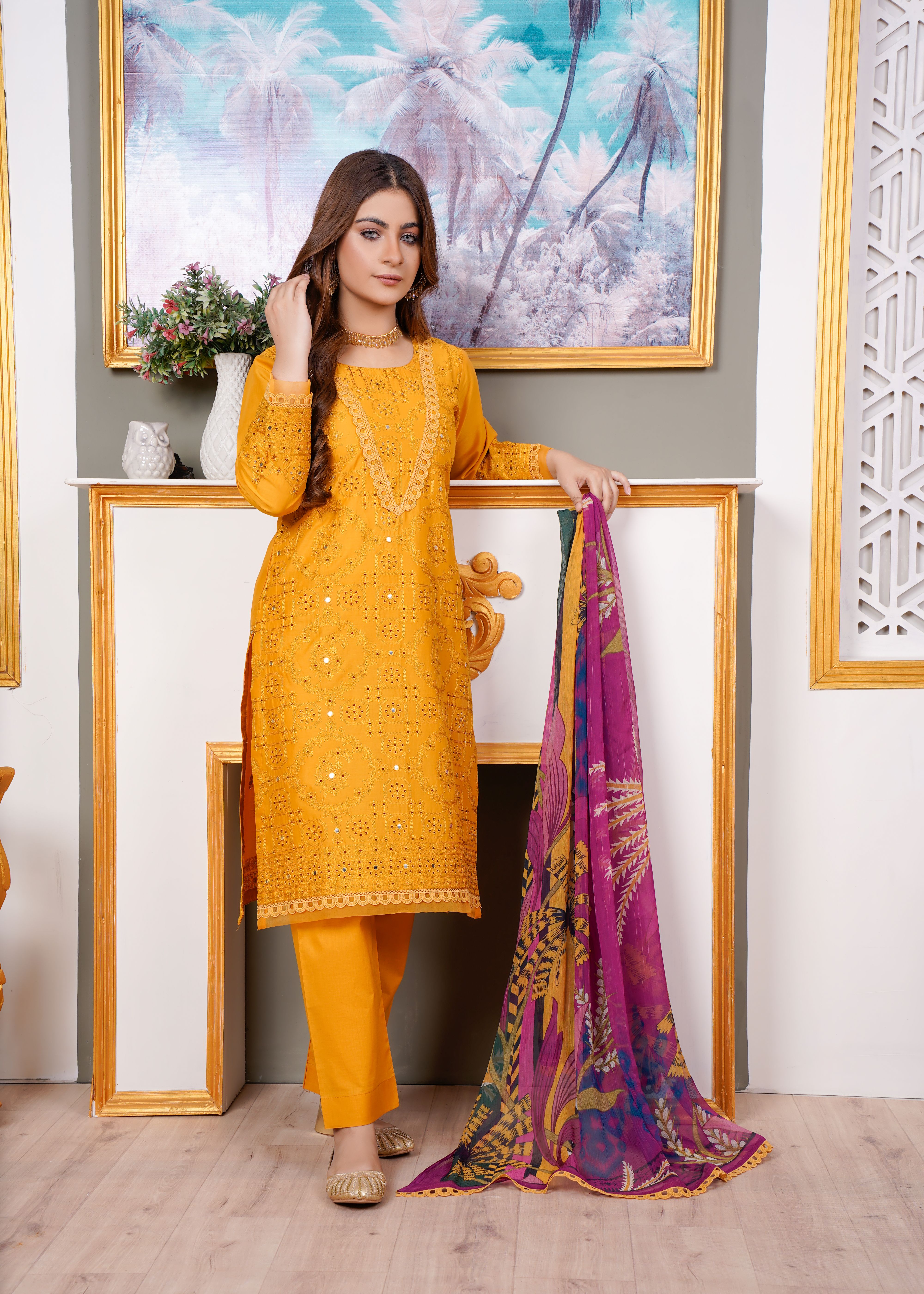 Beautiful woman in a vibrant yellow traditional dress posing indoors, blending style and culture.