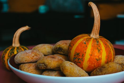 A warm autumn scene featuring homemade buns and decorative gourds, perfect for fall festivities.