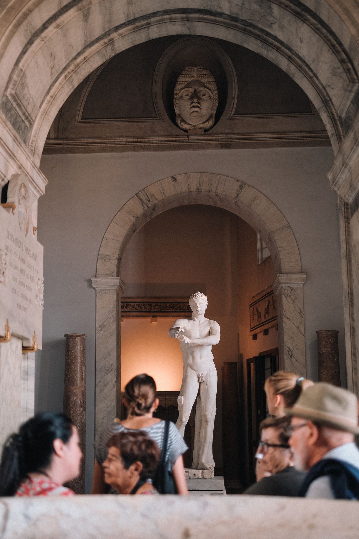 Visiteurs autour d'une statue de marbre dans un musée