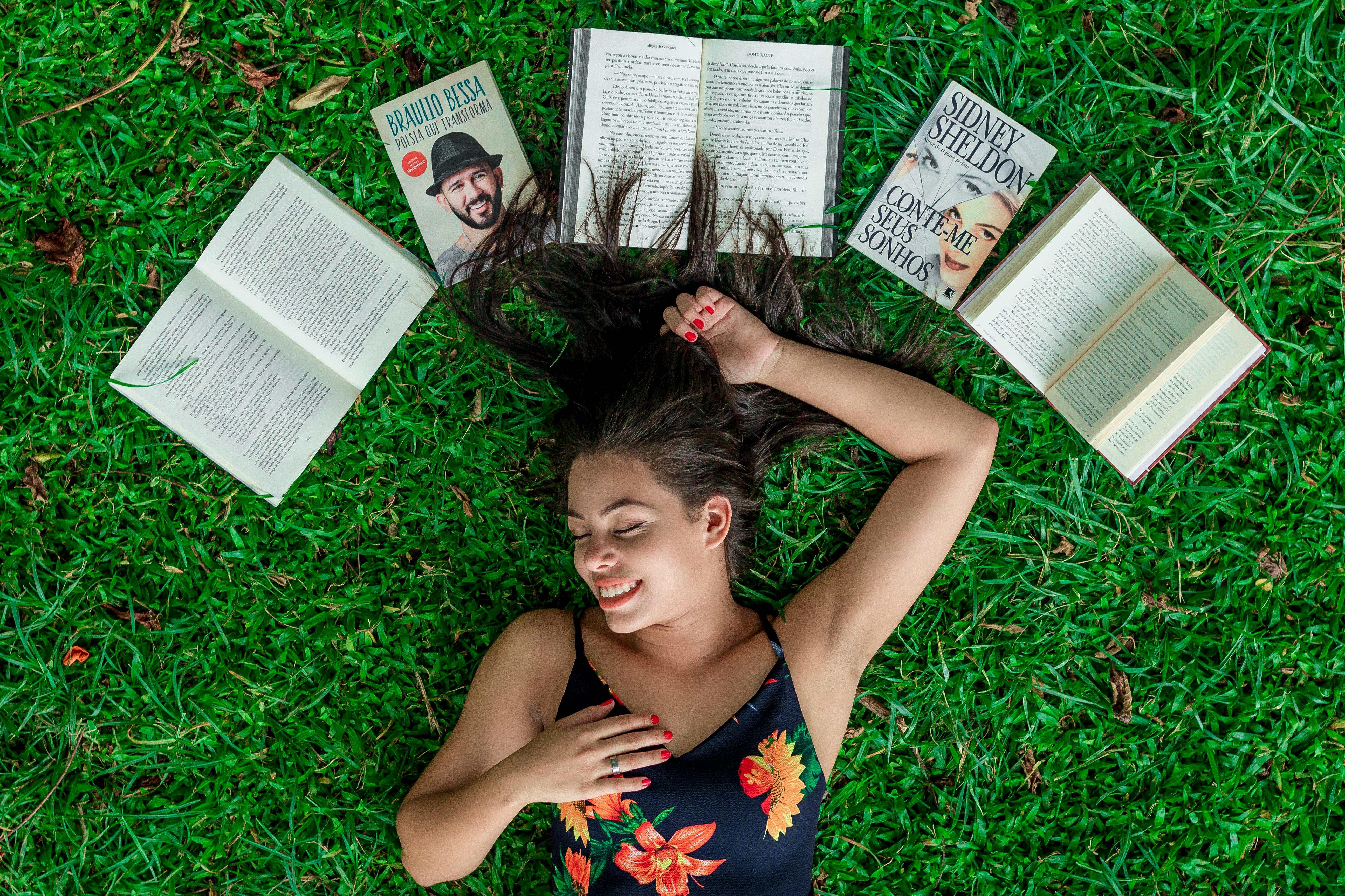 Woman Lying Down on Grass Beside Opened Books · Free Stock Photo