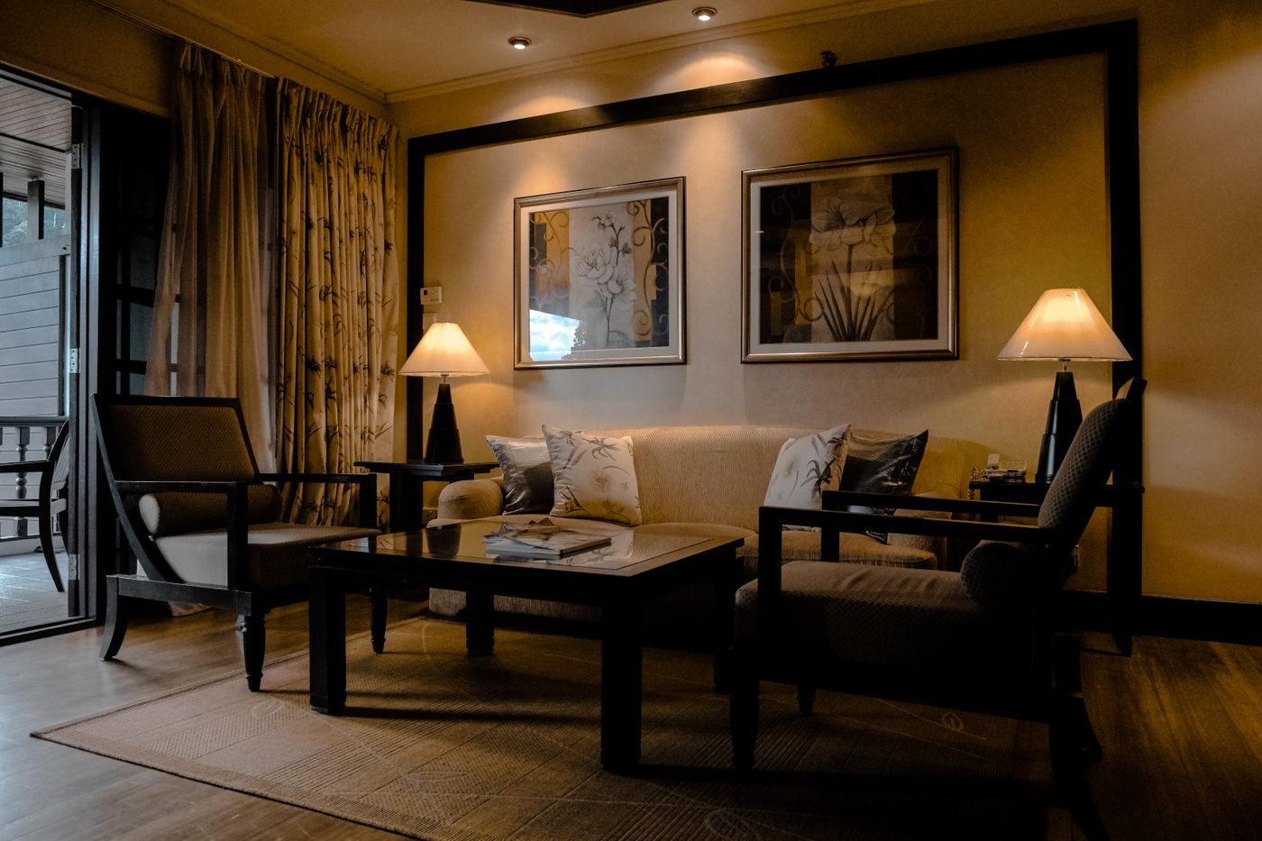 A quiet living corner — elegant furniture, warm lamplight, a moment of calm.