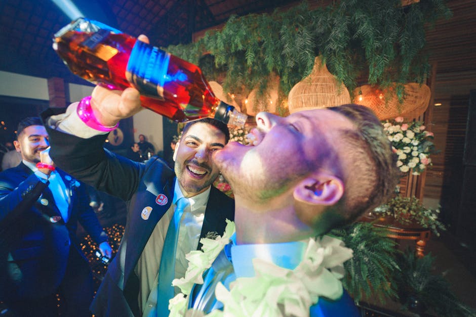 Men celebrating at a party with whiskey, laughter, and fun atmosphere indoors.