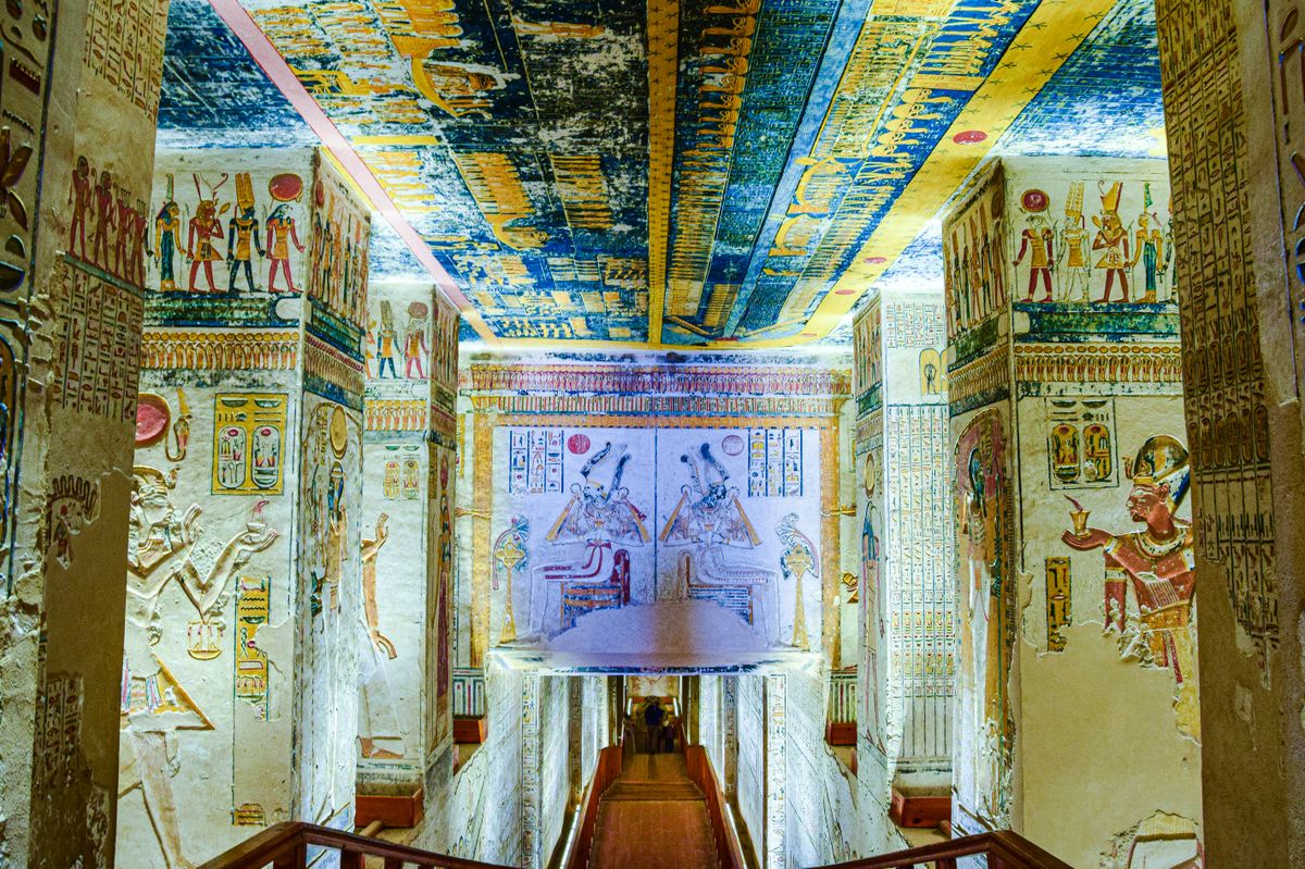 Explore a vividly decorated corridor in an ancient Egyptian tomb, showcasing vibrant hieroglyphs and artwork.
