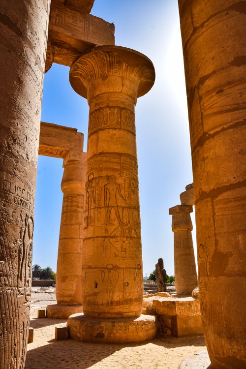 Free Vertical shot of ancient Egyptian temple ruins with hieroglyphics on columns. Stock Photo