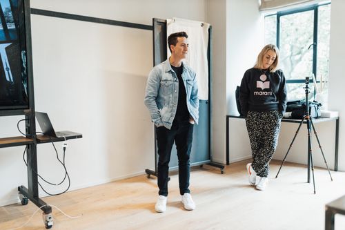 Free Two colleagues in casual attire engage during a relaxed office meeting, showcasing teamwork and creativity. Stock Photo