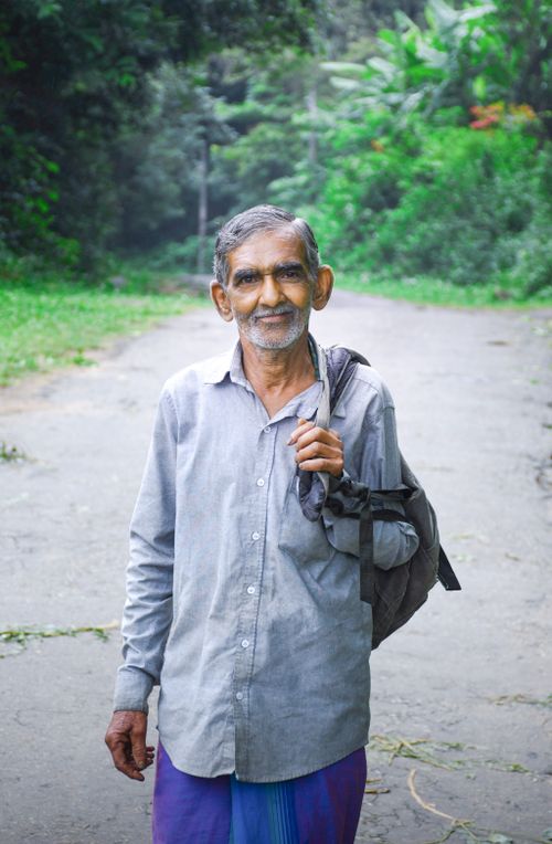 Free Portrait of a smiling elderly man with a backpack on a rural road in Matale, Sri Lanka. Stock Photo