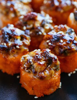 Close-up of delicious baked sushi rolls with a savory glaze, perfect for food lovers.