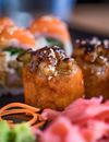 Appetizing fried sushi rolls sprinkled with sesame seeds