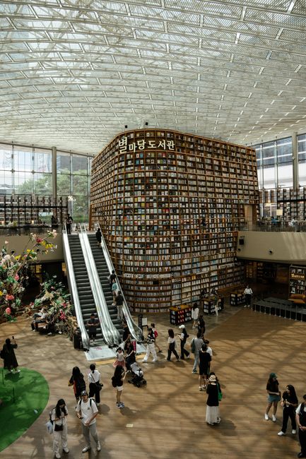 Interior view of Starfield Library in Seoul, showcasing modern architecture and a bustling atmosphere.