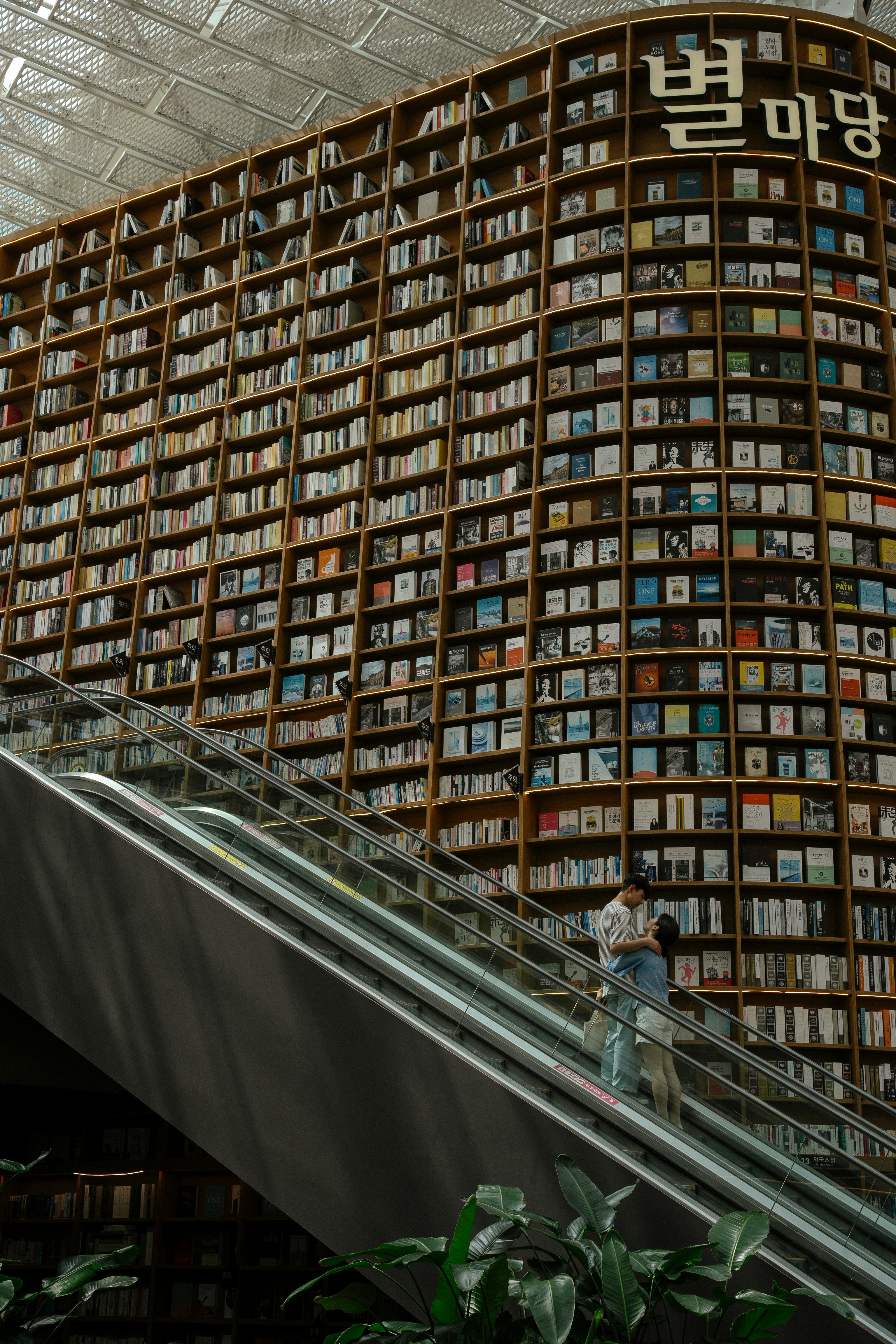 Couple enjoying a moment on an escalator in a massive Seoul bookstore.
