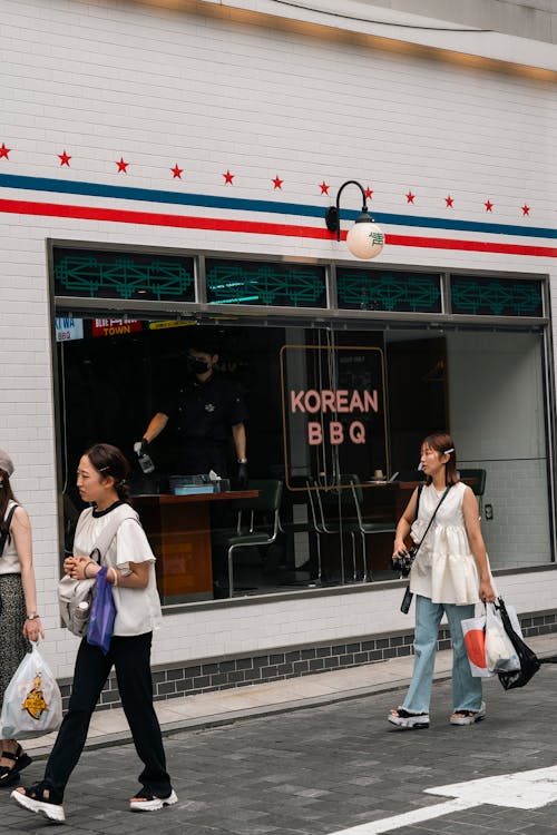 Women Walking near Restaurant Window