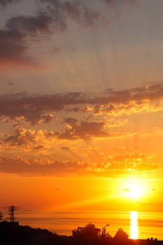 Captivating sunset with vibrant colors and sunbeams reflecting on the ocean, perfect for travel and nature themes.