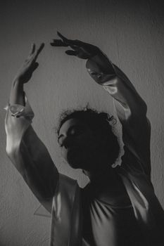 Artistic black and white portrait of a dancer captured in a silhouette with elegant movement.