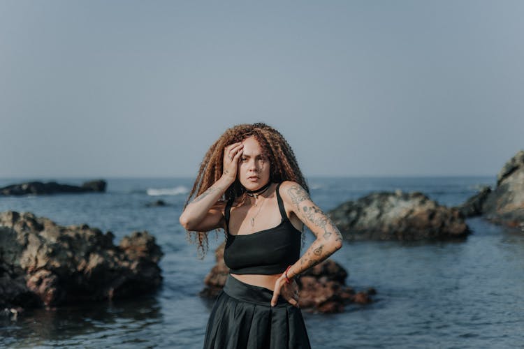 Woman Posing In Black Outfit On A Beach 