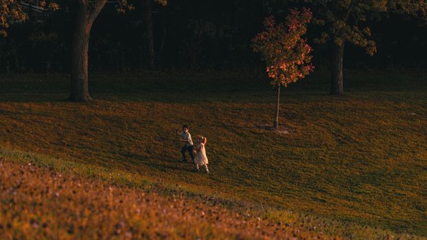 Two children enjoying a playful moment in a Toronto park on an autumn day.