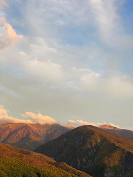 Golden sunlight illuminates the mountain range in Dibër County, Albania.