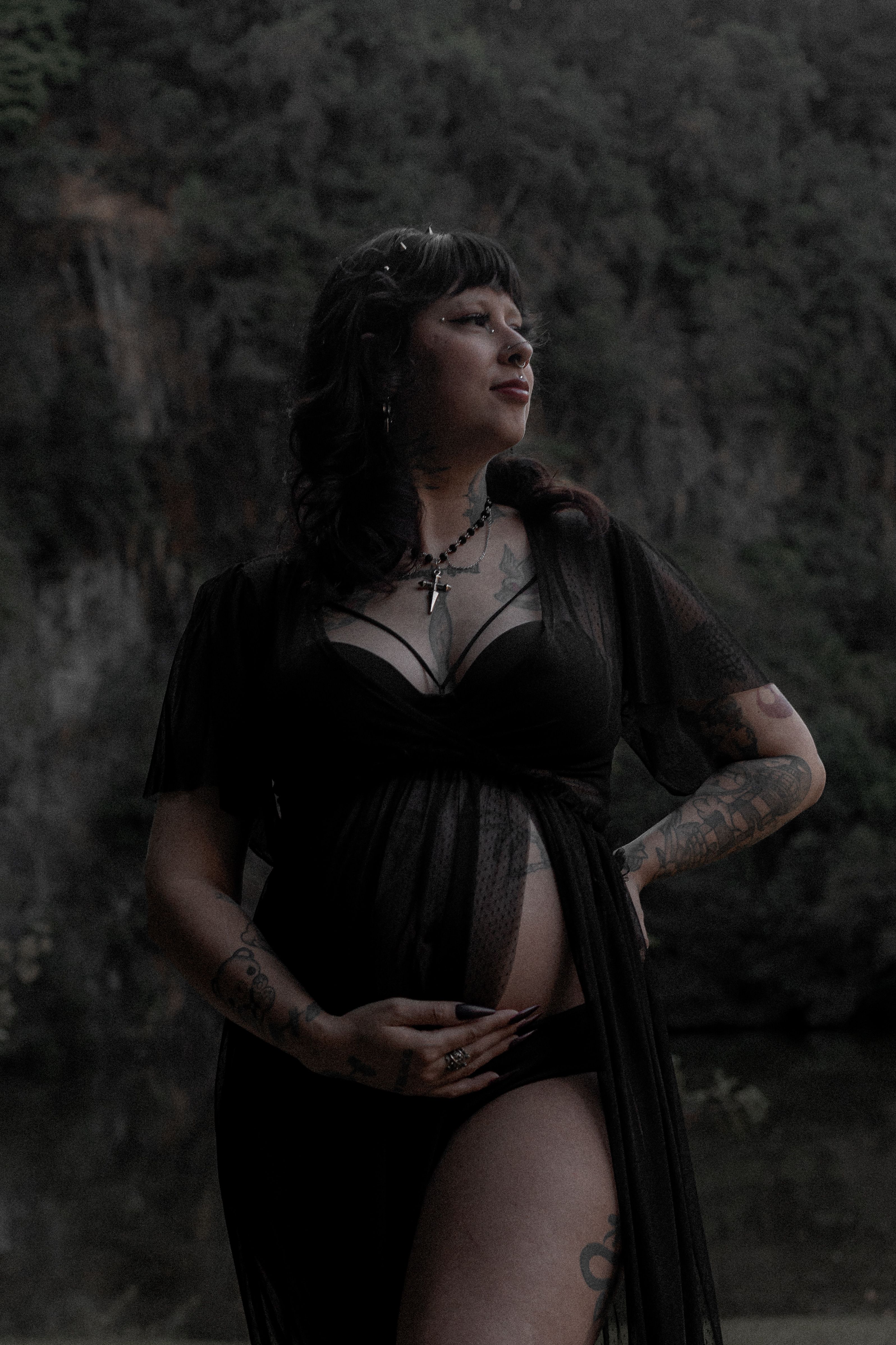Pregnant Woman in a Black Dress with her Hand on Belly  Free Stock Photo
