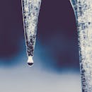 冬季环境中，捕捉冰柱融化的水滴细节的宏观镜头