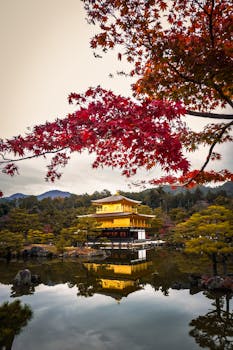Stunning view of Kinkaku-ji temple reflecting in the waters surrounded by autumn foliage in Kyoto, Japan.