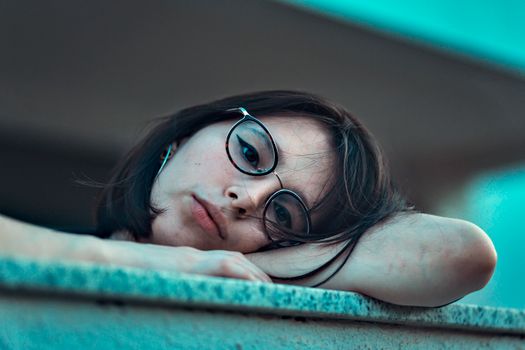 Photo of Woman in Eyeglasses Resting Her Head on Arm