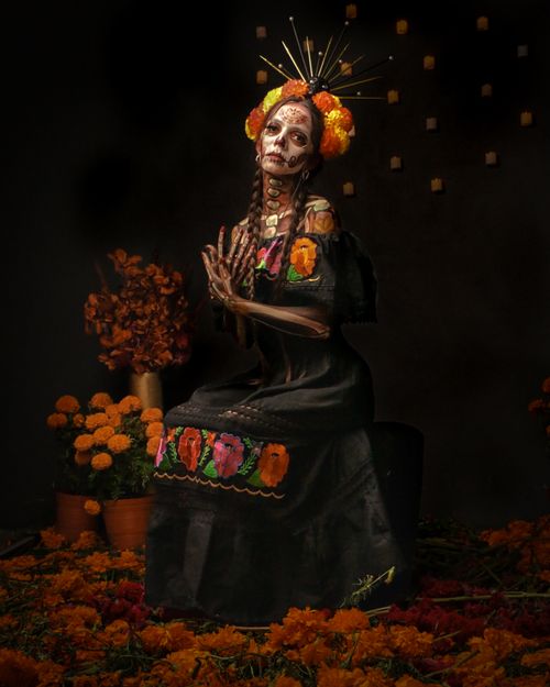 Free A woman in traditional Dia de los Muertos costume adorned with a flower wreath and painted face. Stock Photo