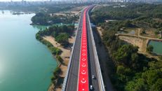Scenic aerial capture of a Turkish highway in Adana adorned with national flags.