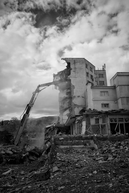 Excavator on the Rubble and a Damaged Building 