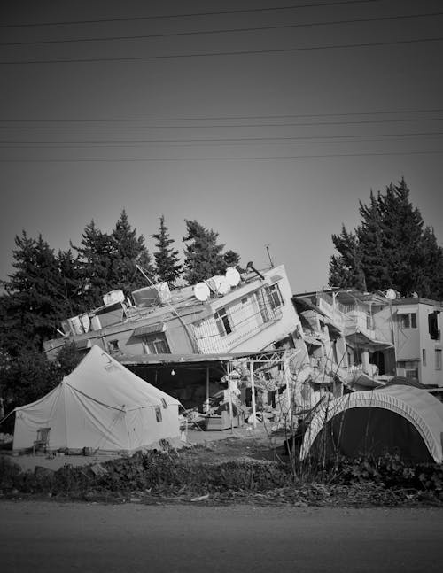 Tent in front of a House Ruined during Earthquake