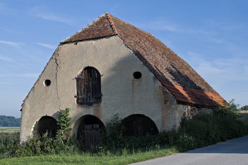 Old Abandoned and Cracked Barn with Red Tile Roof 