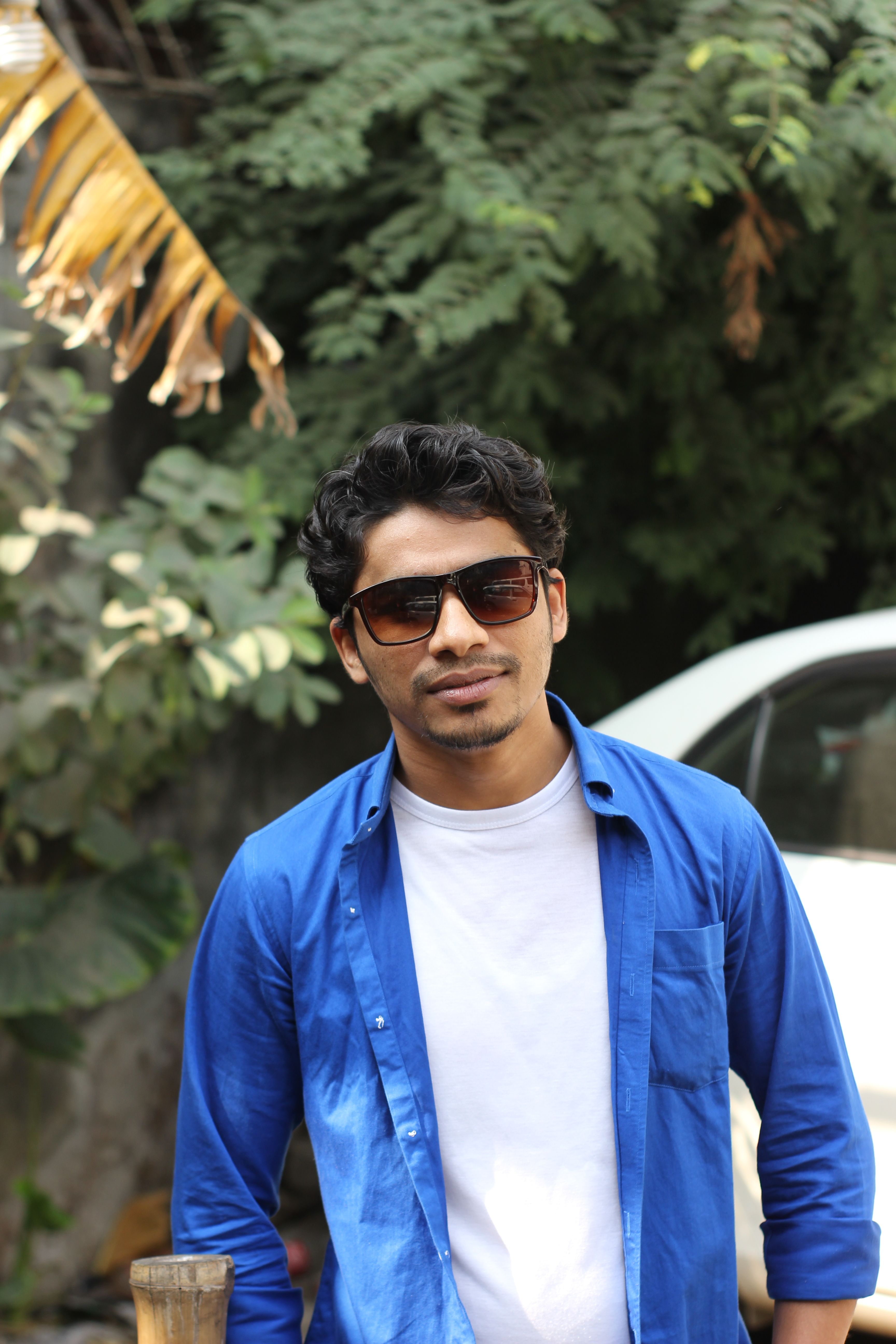 Portrait of a Man in a Blue Shirt and Sunglasses Standing Outside ...