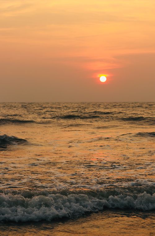 Free A tranquil sunset view over a calm ocean, capturing the beauty of nature's warm hues. Stock Photo