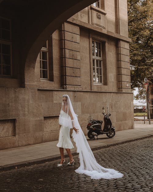 Bride Dragging Her Long Veil on Cobblestone in the Street