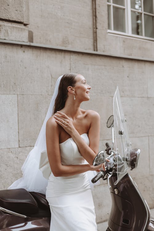 Bride in White Off the Shoulder Wedding Dress and Veil Sitting on a Vespa Scooter