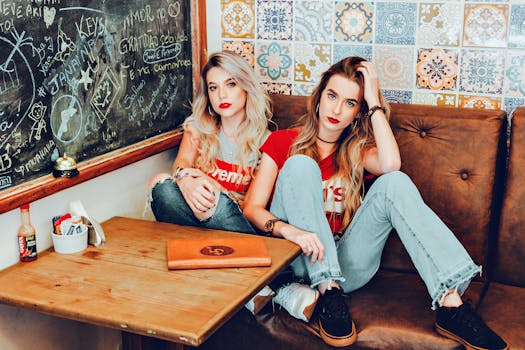 Two stylish women in a cafe with vintage decor and denim fashion.