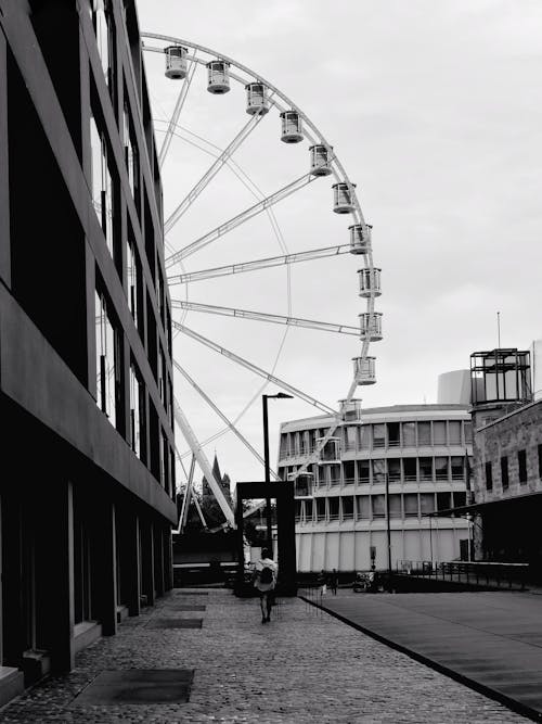 Person on Street in Front of Ferris Wheel