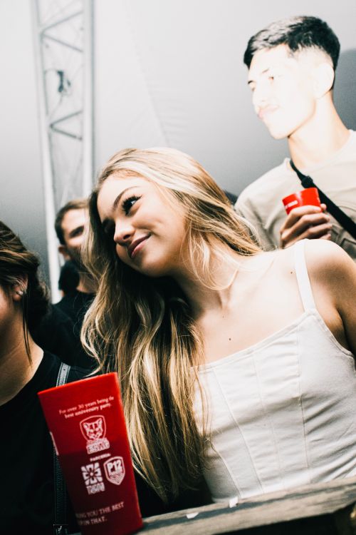 Free Group of young adults smiling and enjoying a night out at a lively party with drinks. Stock Photo