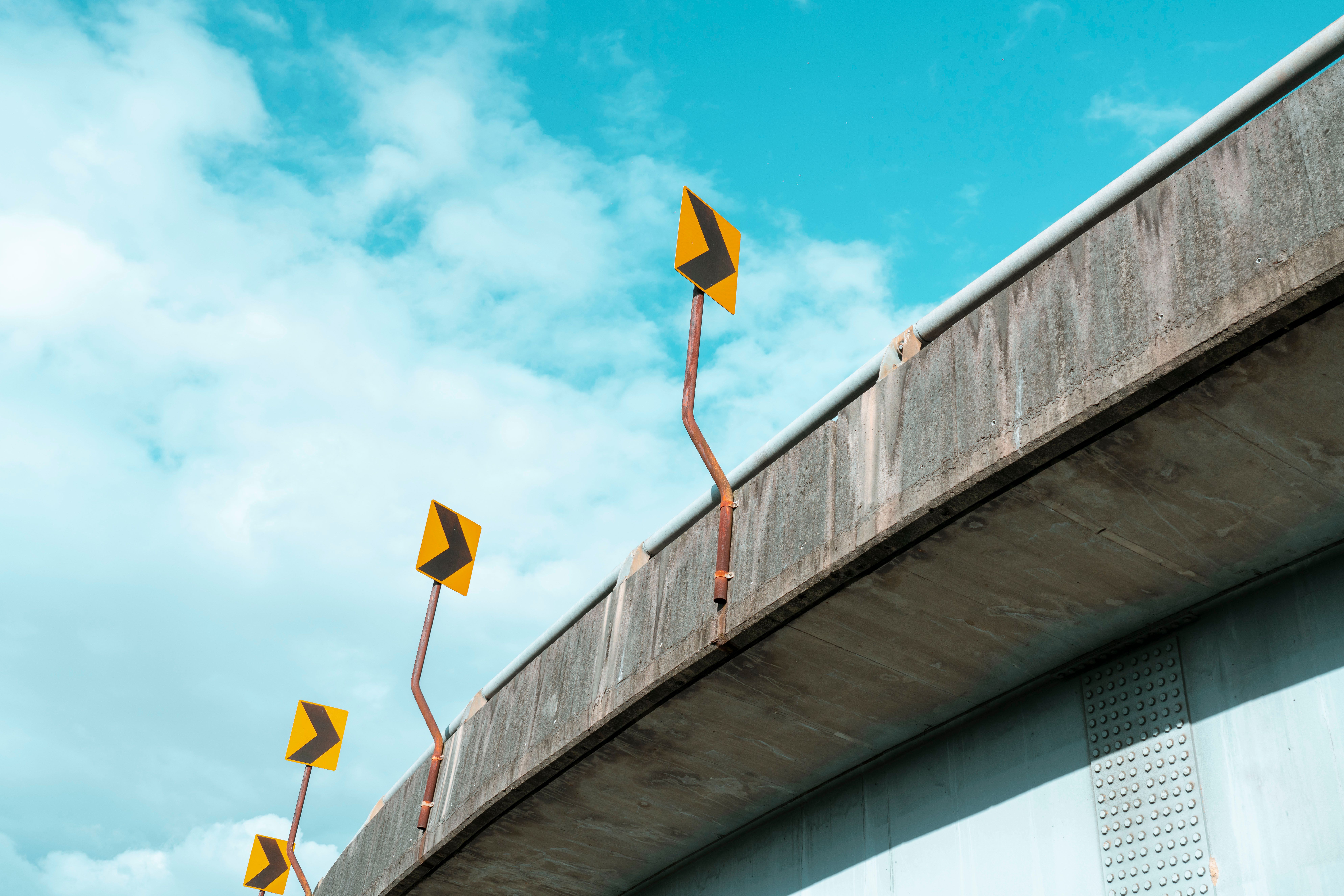 Rusty Posts with Road Signs on Wall · Free Stock Photo