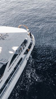High angle view of a white passenger ship sailing through deep blue waters, showcasing luxury travel.