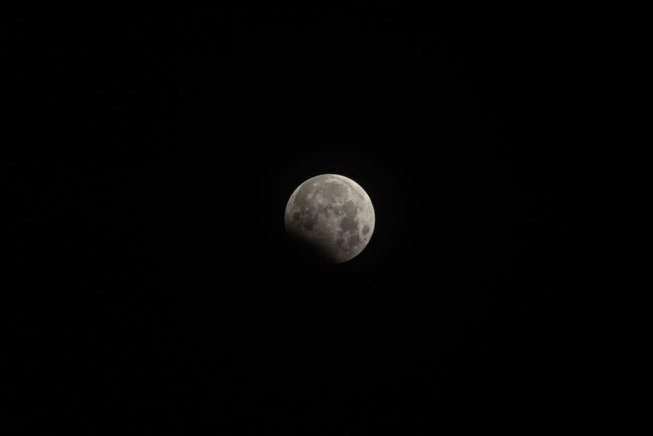 A clear view of the moon during a lunar eclipse with shadowed detail.