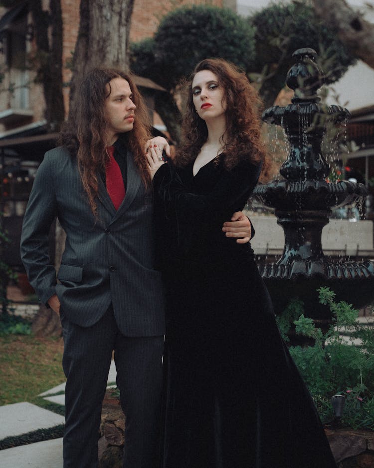 Man In Black Suit With Arm Around Womans Waist