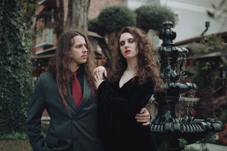 Man Embracing Woman Dressed In Black Gown