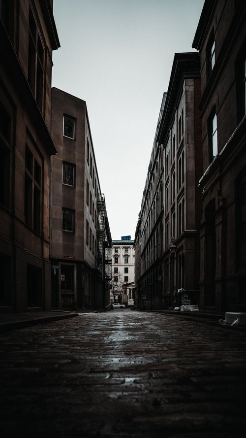 Free Dramatic view of a narrow alleyway in Old Montreal, showcasing urban architecture. Stock Photo