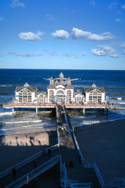 A scenic view of a historic building on a pier extending into the Baltic Sea in Germany.