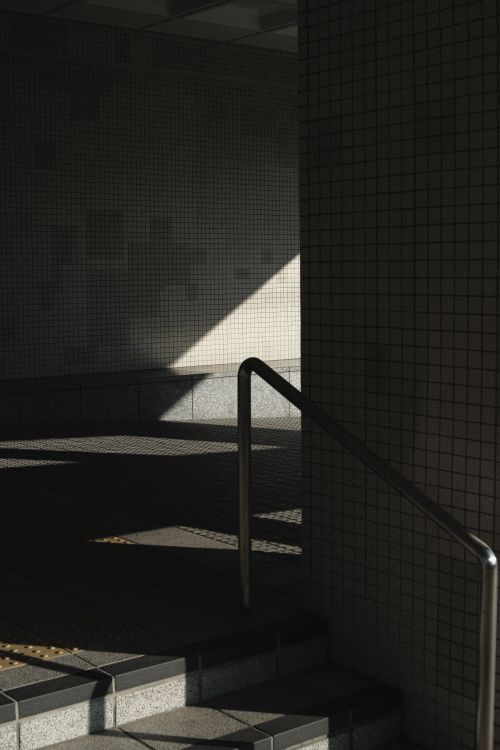 Free Geometric shadows on an urban tiled stairway create a moody atmosphere. Stock Photo