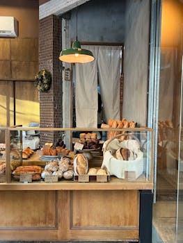 Inviting bakery display featuring an array of freshly baked bread and pastries under warm lighting.