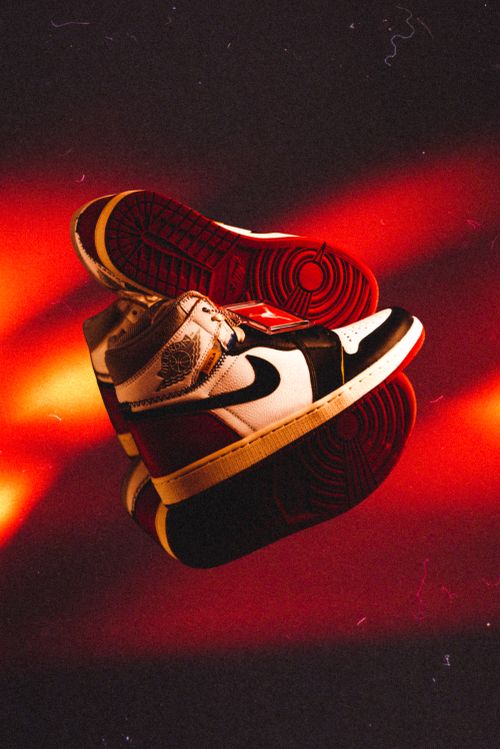 Free Close-up of high-top sneakers showcasing fashion-forward design against a bold red background. Stock Photo
